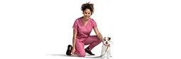 A female vet kneels next to a dog.